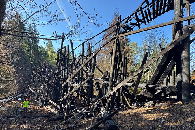 Charred timber and hanging rail are all that remain of the bridge. Charred timber and hanging rail are all that remain of the bridge.